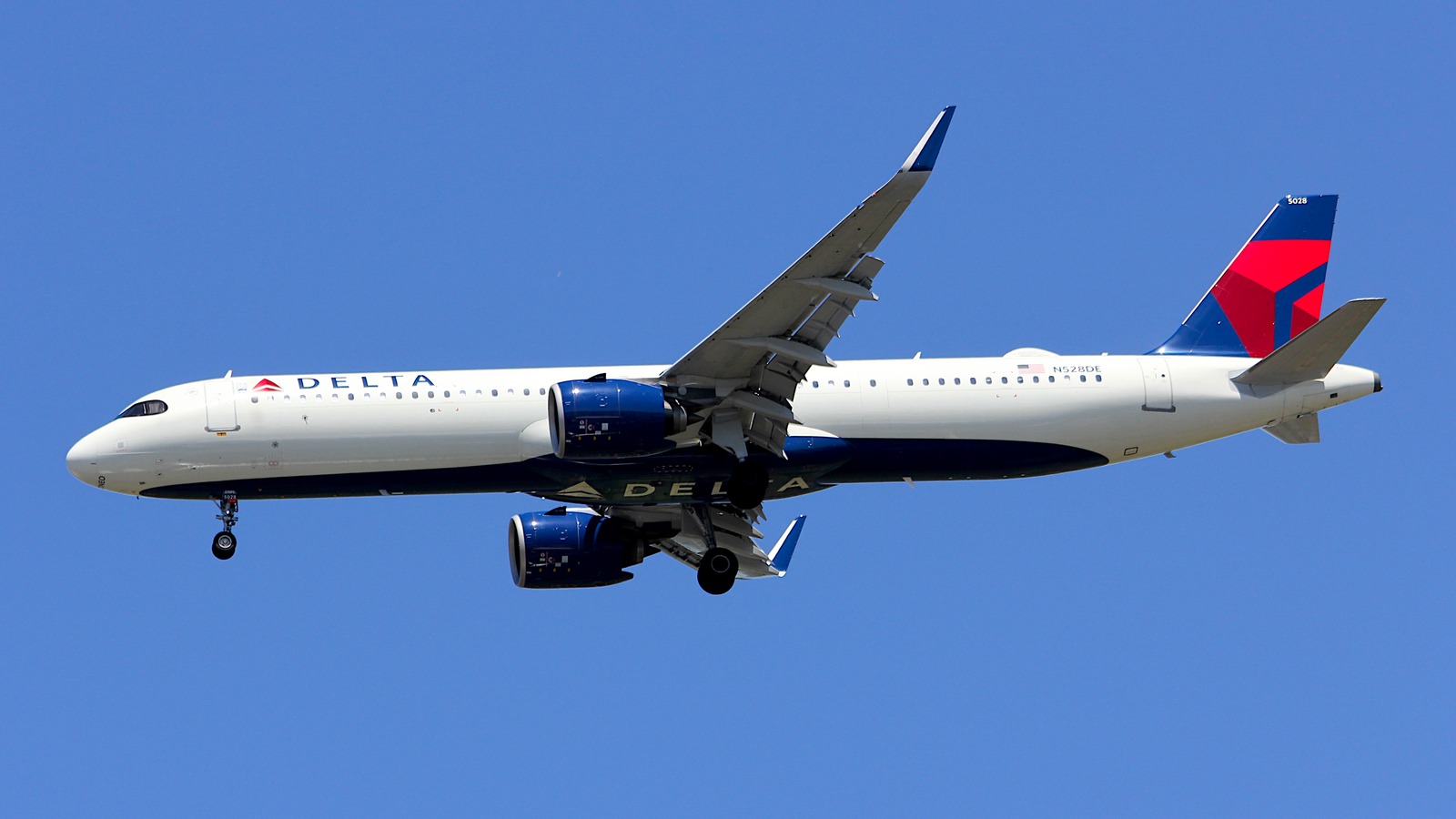 Delta Air Lines Airbus A321 in flight against a clear blue sky