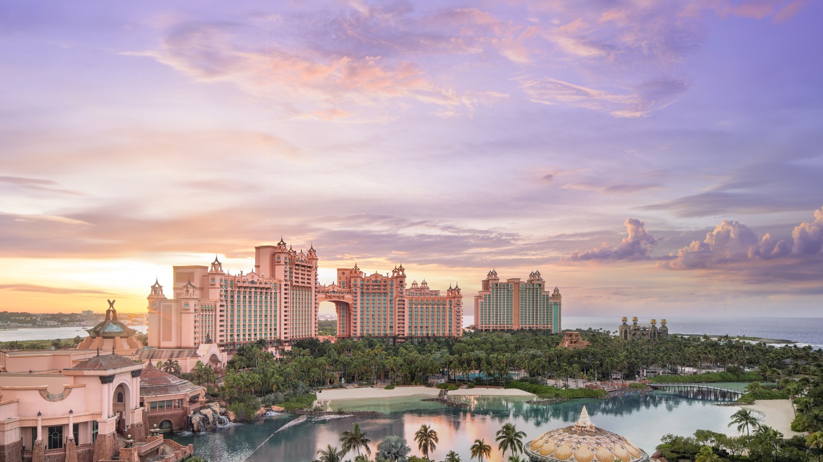 Coral-pink Royal Towers at Atlantis Paradise Island with marina and lagoon in the foreground under bright sky