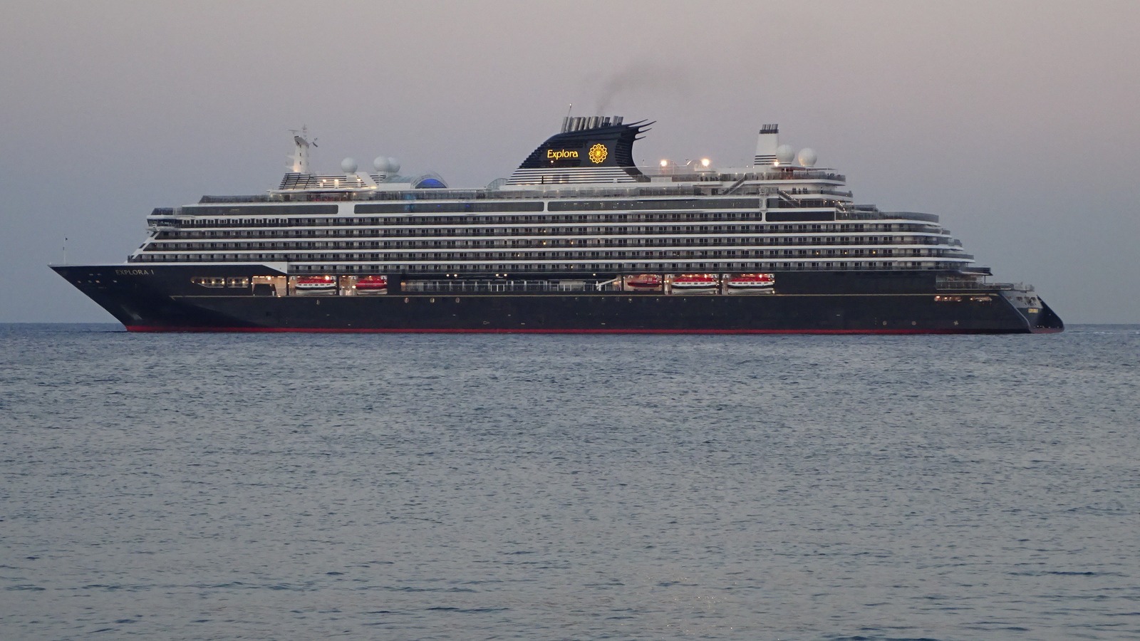 Explora I cruise ship leaving the Port of Rhodes under a clear sky