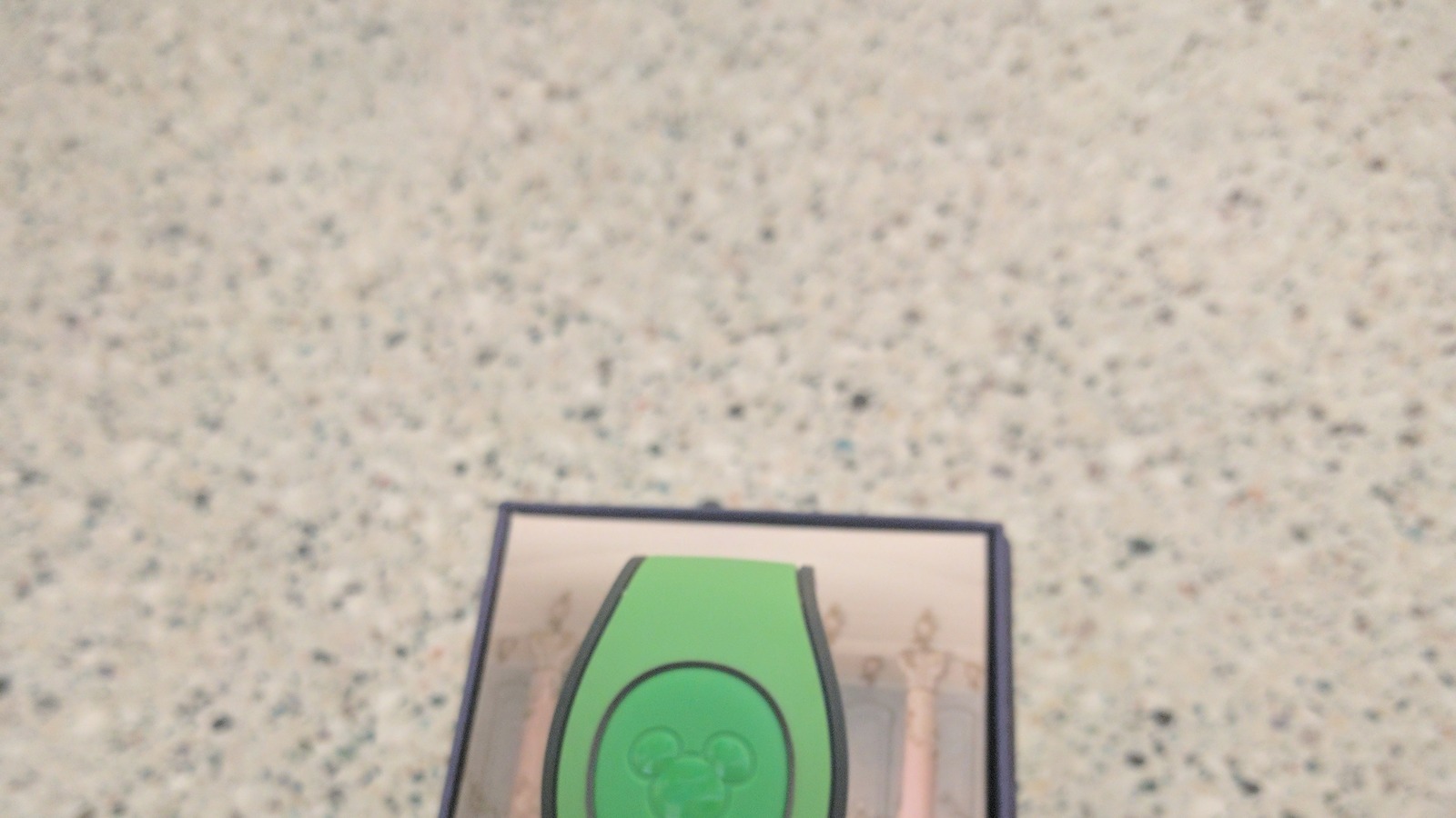 Green Disney MagicBand wearable in packaging, the hardware path that still supports MagicBand+ park interactions after Play Disney Parks app login ends