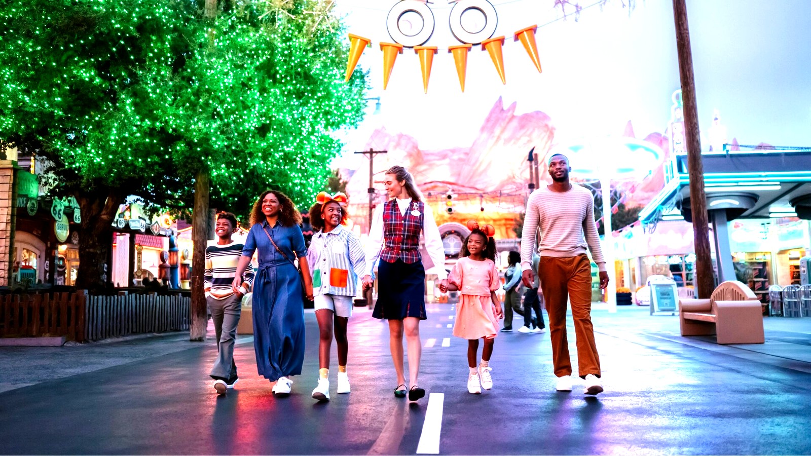 Guests walking through Cars Land area during Oogie Boogie Bash themed evening at Disney California Adventure