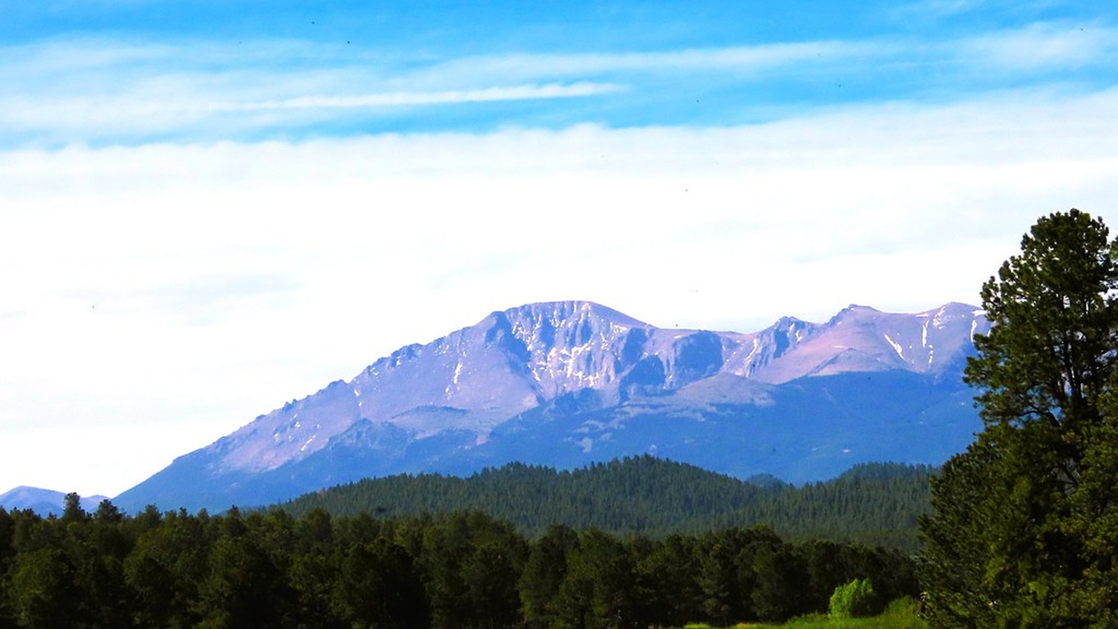 Pikes Peak rising above forest and shoreline on Pike National Forest