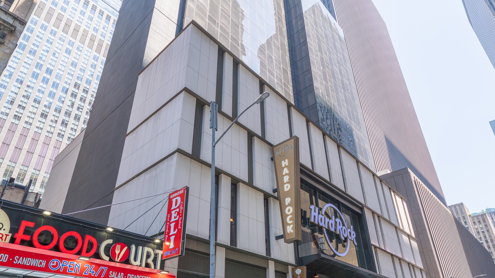 Street-level daylight view of Hard Rock Hotel New York in Midtown Manhattan with the vertical HARD ROCK blade and circular Hard Rock mark