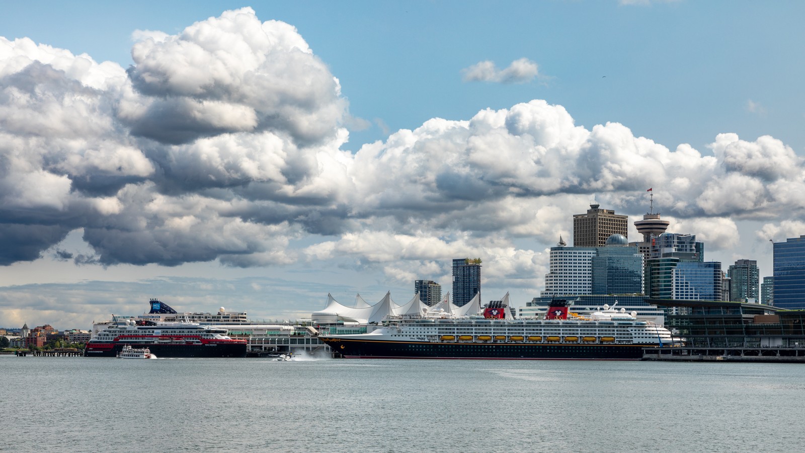Canada Place cruise terminal sails structure and pier in Vancouver with ships alongside