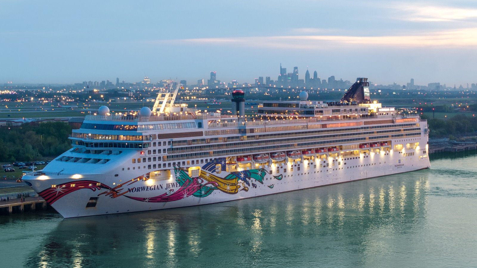 Norwegian Jewel docked at PhilaPort with the Philadelphia skyline behind it