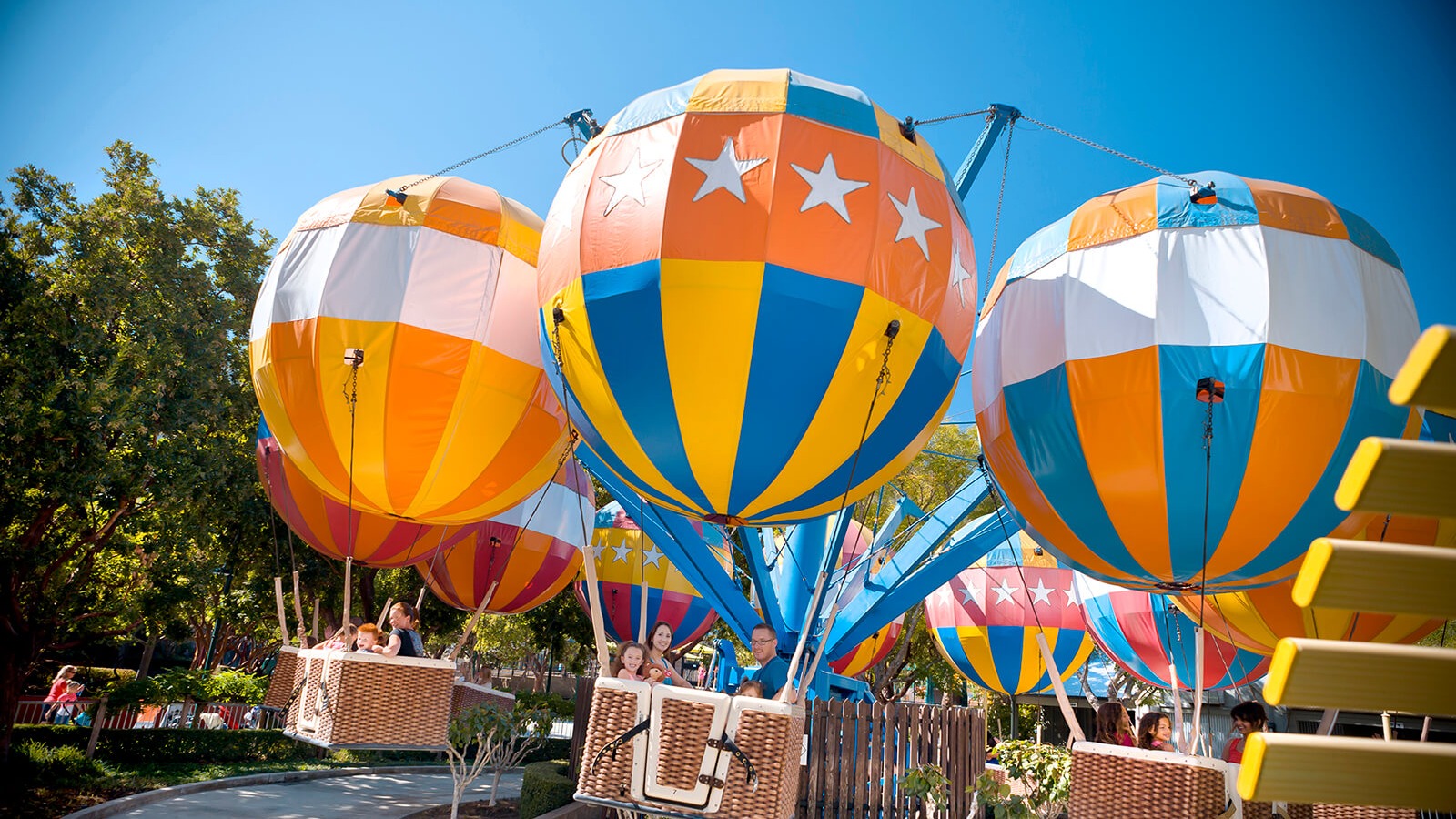 Colorful balloon ride gondolas at Gilroy Gardens Family Theme Park under a bright blue sky