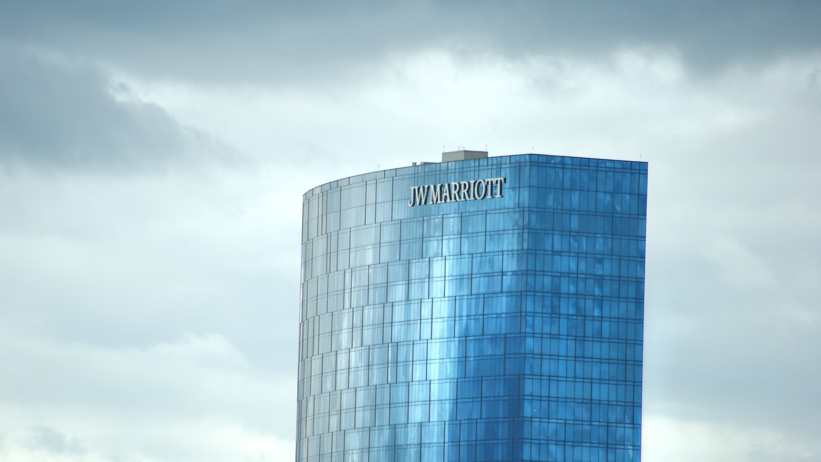 JW Marriott Indianapolis glass hotel tower under a bright cloudy sky