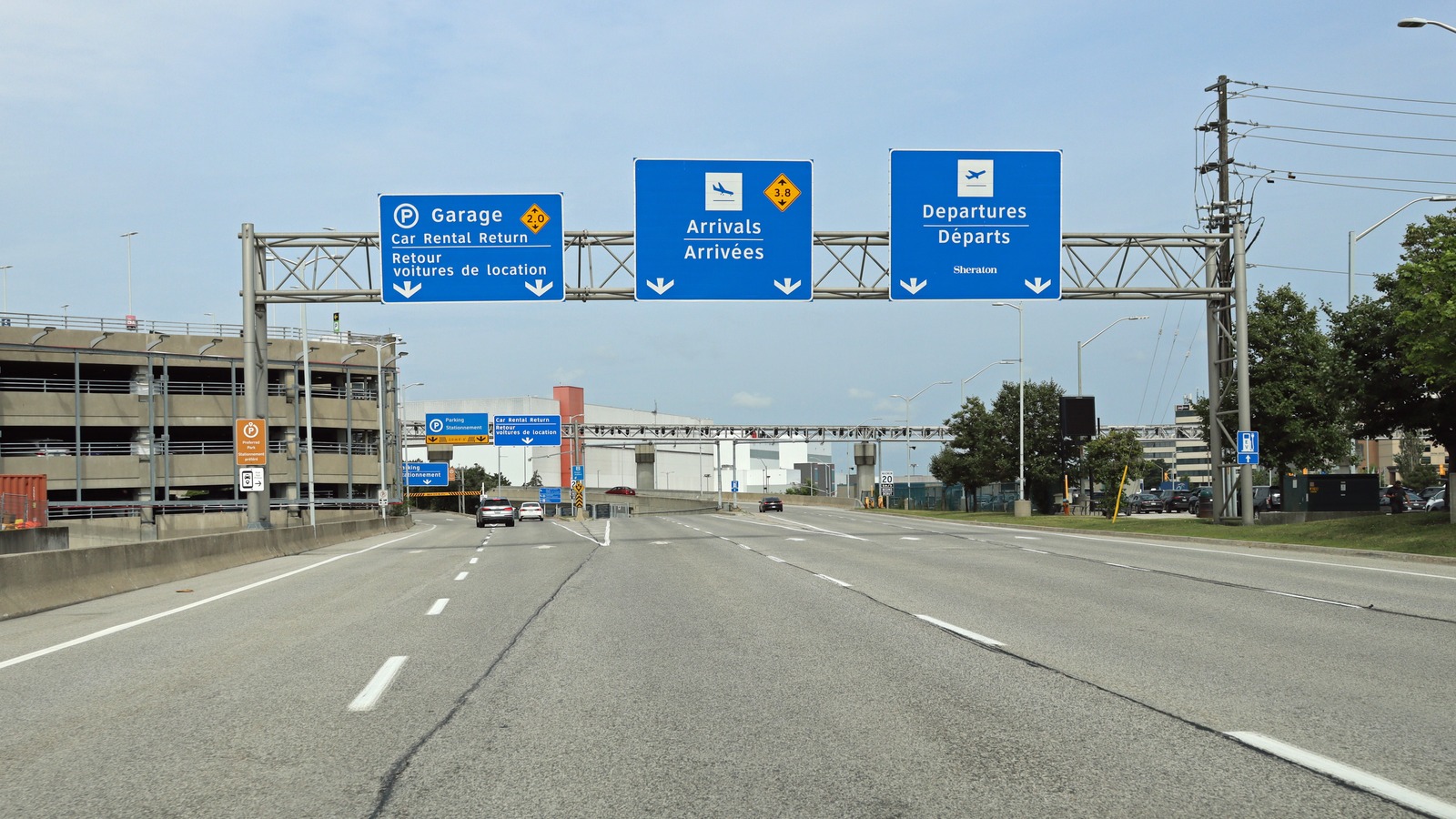Approach road to Toronto Pearson Terminal 3 with bilingual Arrivals and Departures overhead signs