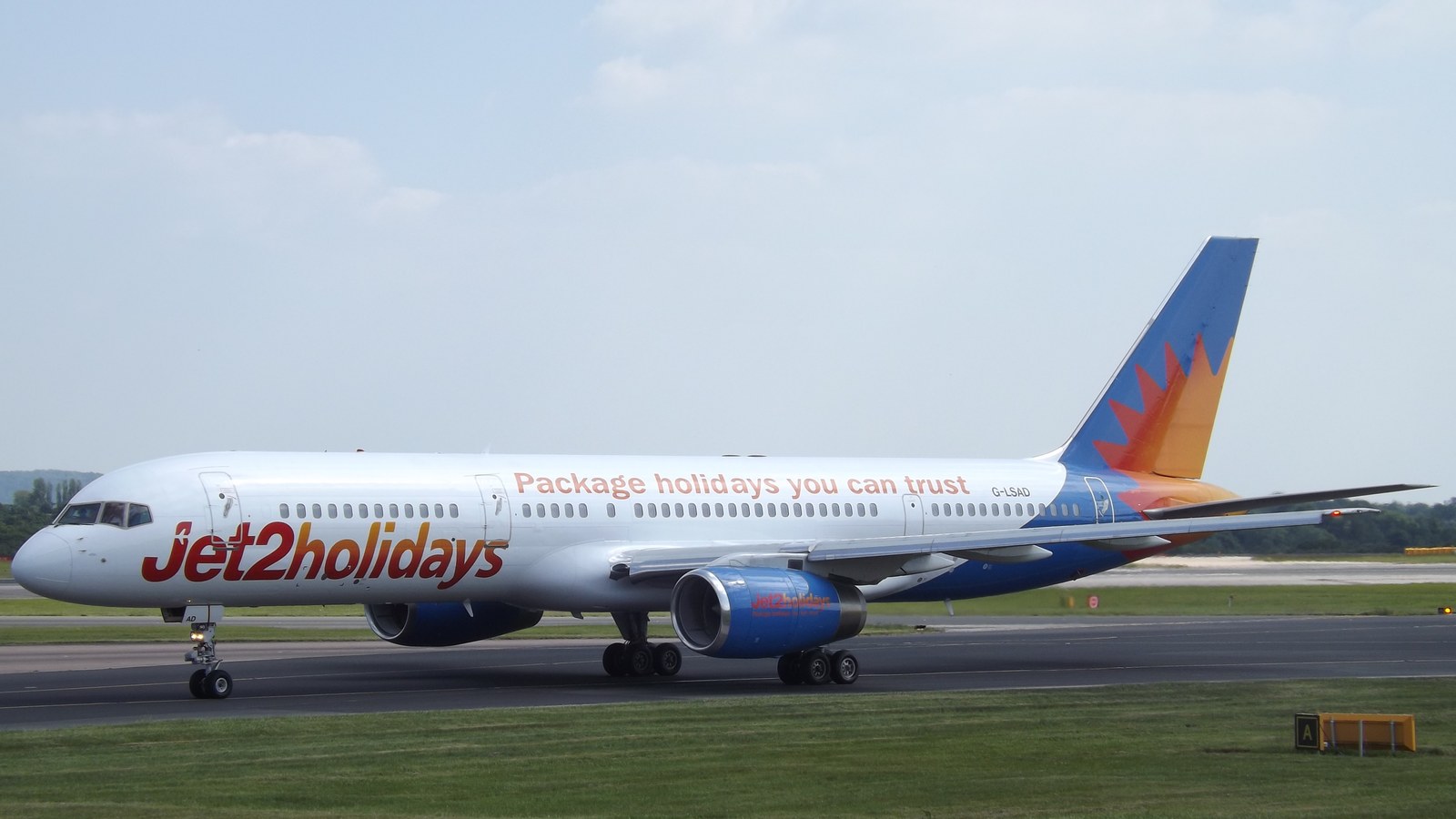 Jet2.com Boeing airliner in red and white livery on the ground with brand titles visible on the fuselage