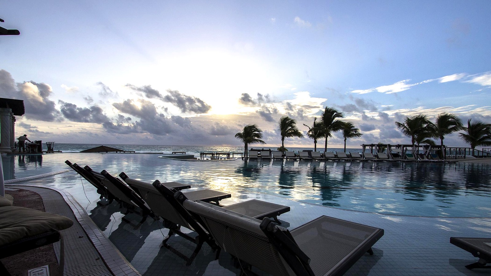 Infinity pool lounge chairs and palm trees at Hyatt Zilara overlooking the Caribbean