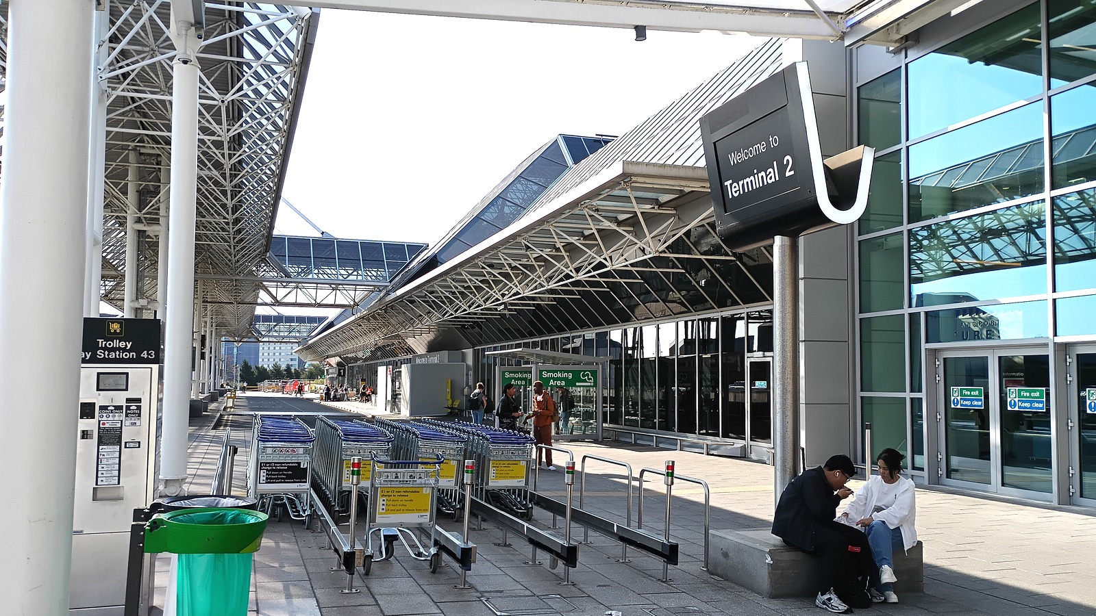 Exterior of Terminal 2 at Manchester Airport with glass facade and approach roadway