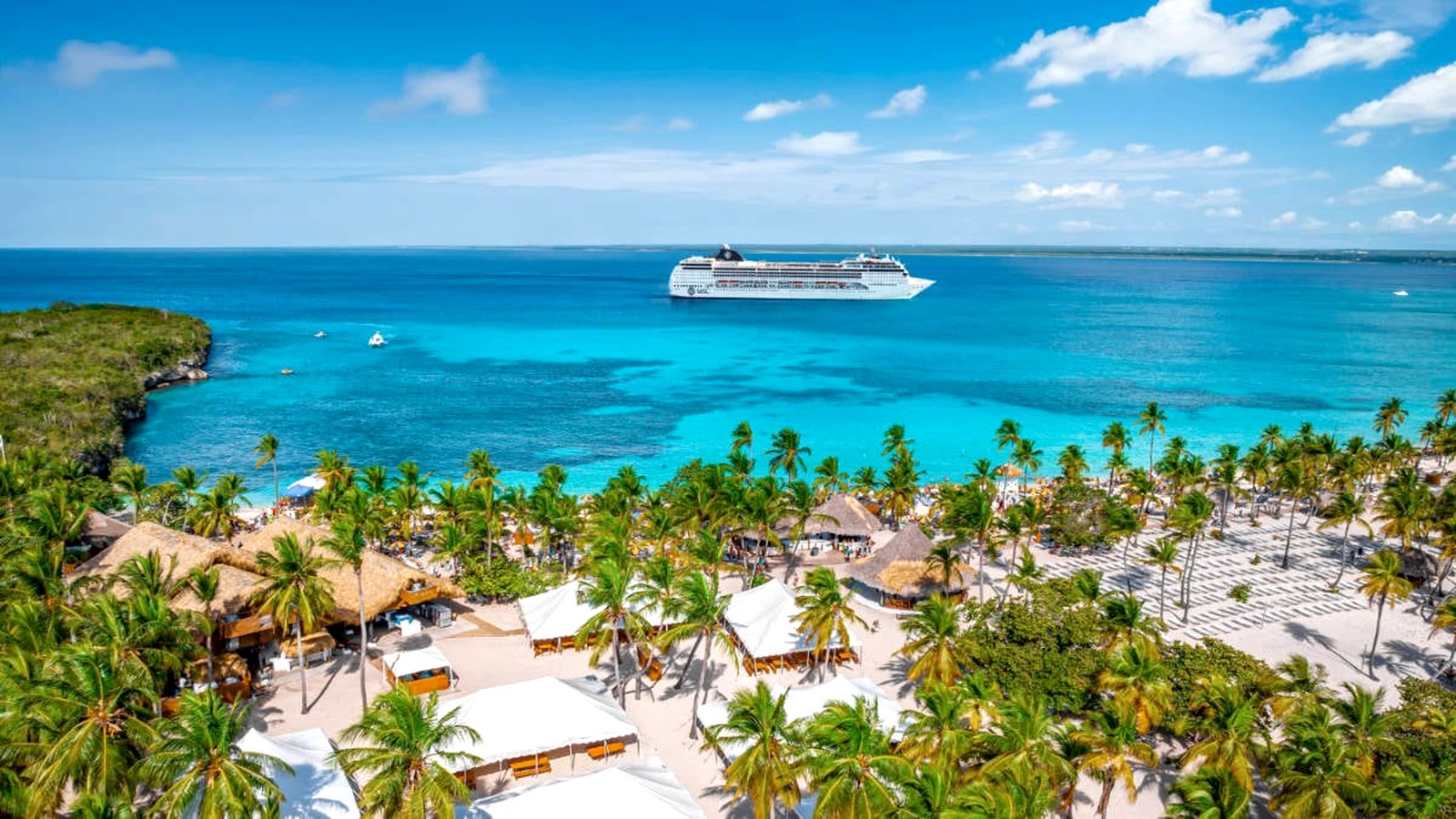 Aerial view of Catalina Sugar Beach cabanas palms and an MSC cruise ship offshore