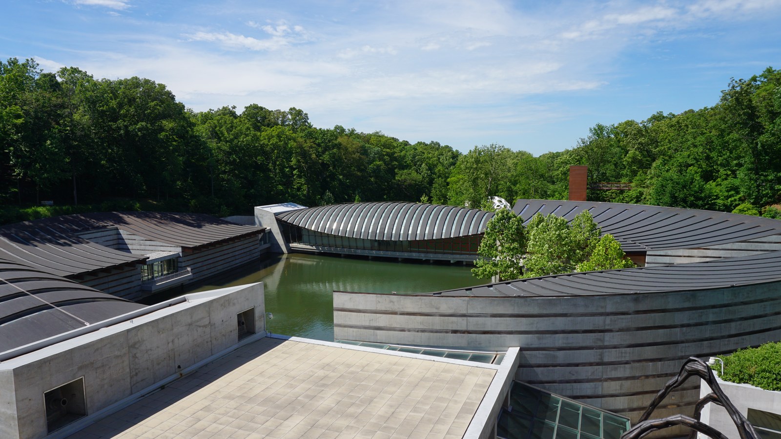 The curved copper and glass pavilions of Crystal Bridges Museum of American Art spanning the spring fed ponds in Bentonville, Arkansas