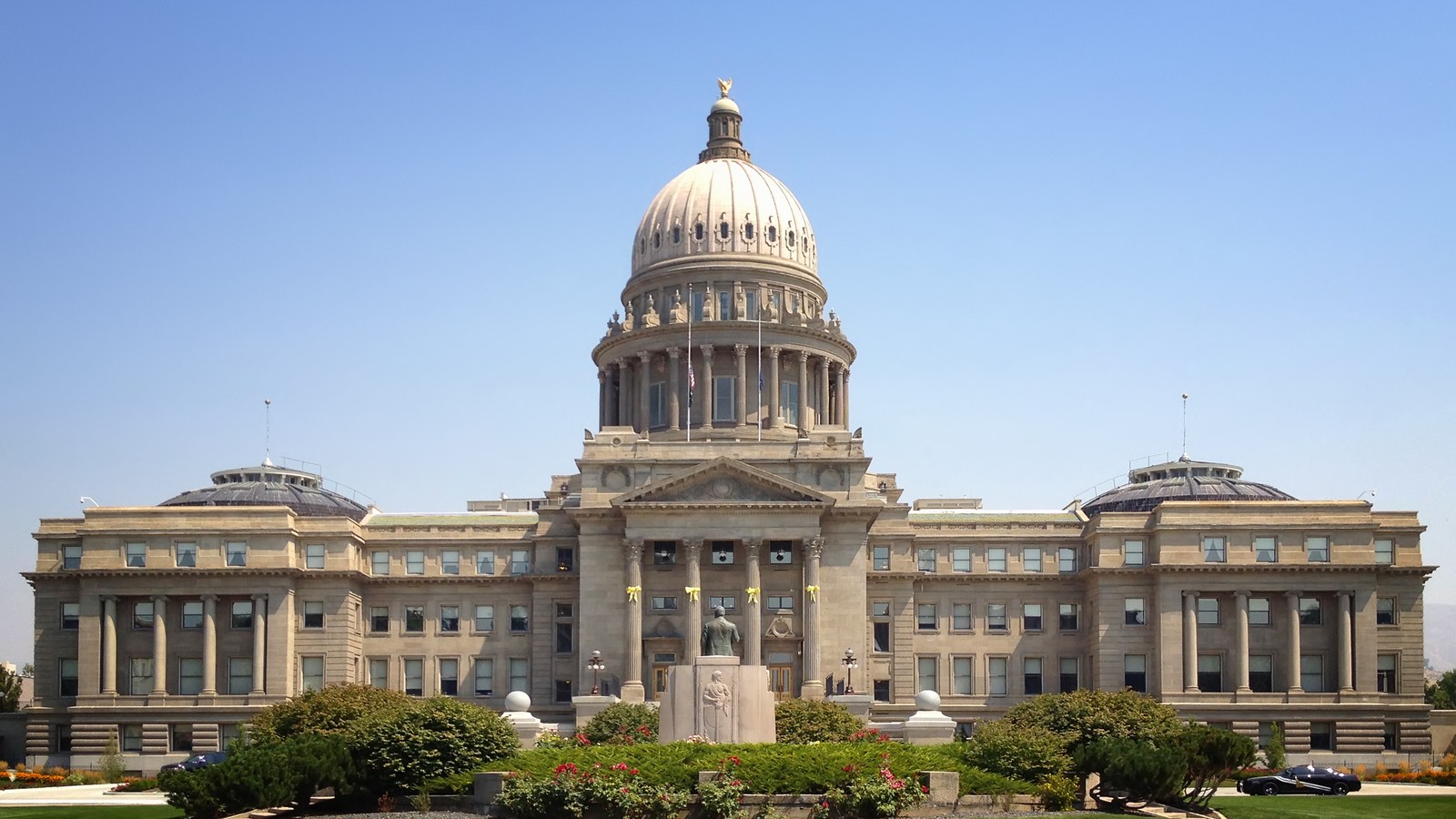 The sandstone dome and columned front of the Idaho State Capitol in Boise under a clear sky