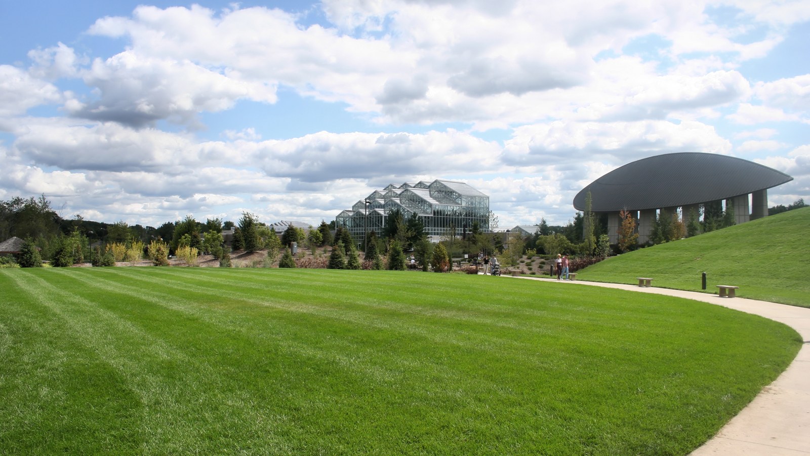 The glass conservatory and amphitheater at Frederik Meijer Gardens in Grand Rapids seen across a wide green lawn