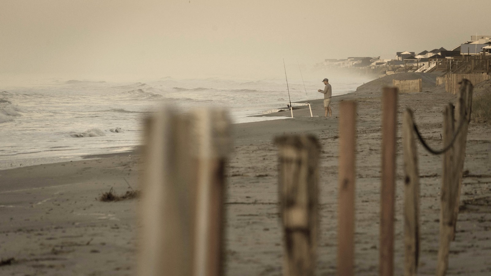 An angler surf casting from Oak Island beach