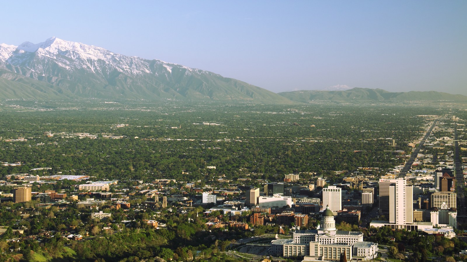 Salt Lake City spread across its valley with the snow capped Wasatch Range rising behind the downtown skyline