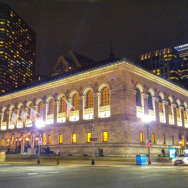 The illuminated McKim Building of Boston Public Library beside Copley Square at night