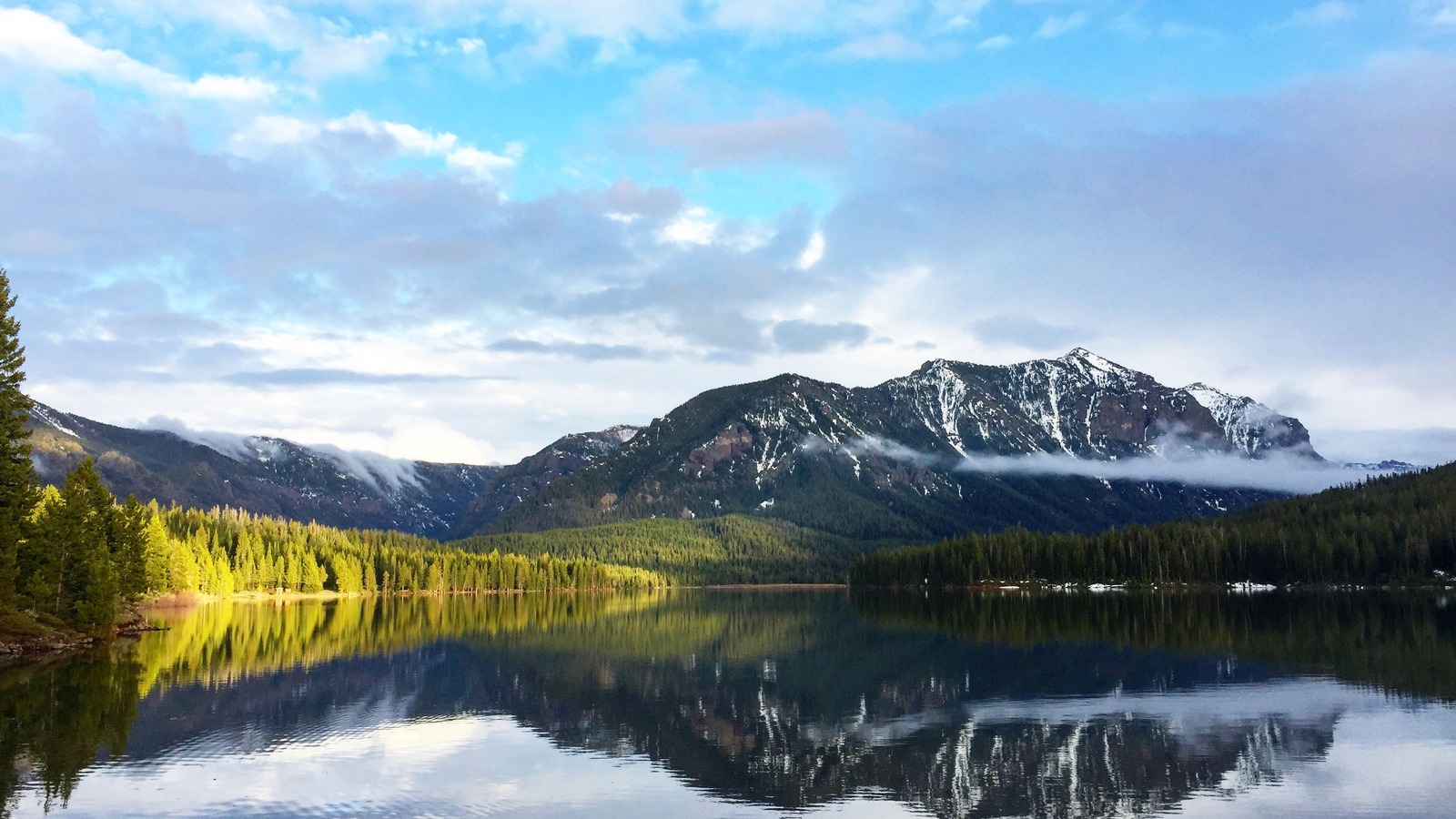 Hyalite Reservoir south of Bozeman, Montana, with snow streaked peaks reflected in calm water