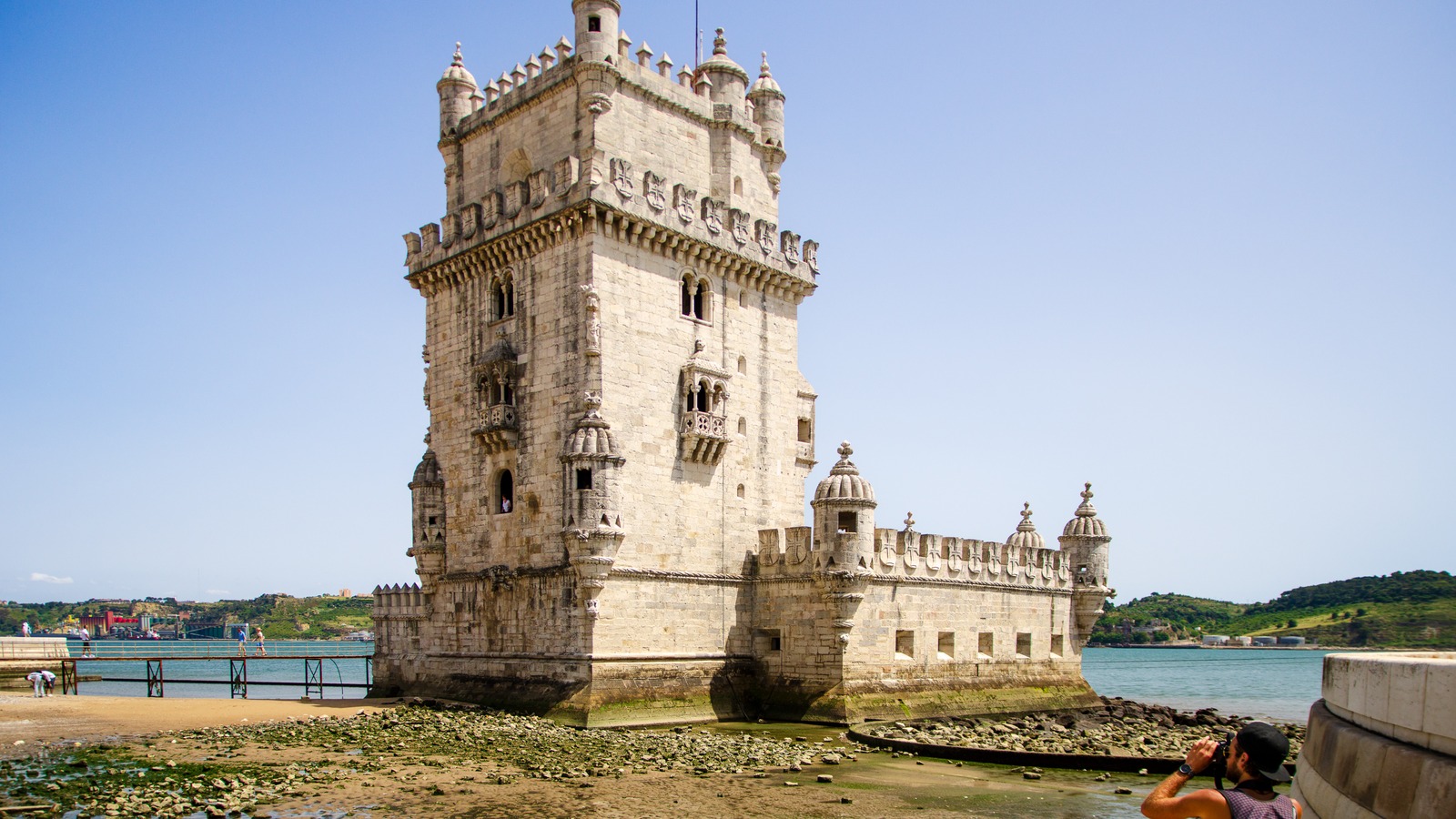 The stone Belem Tower standing at the edge of the Tagus river in Lisbon under a clear sky
