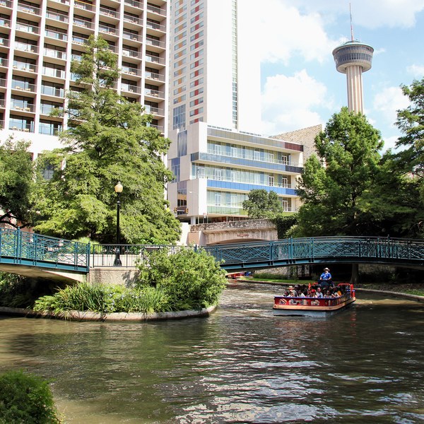 The San Antonio River Walk with riverside paths and the Tower of the Americas beyond