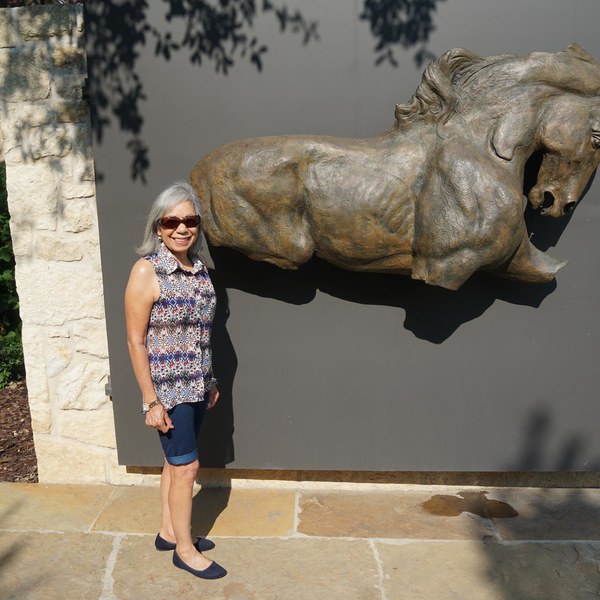 A visitor beside a bronze horse sculpture at the Briscoe Western Art Museum in San Antonio