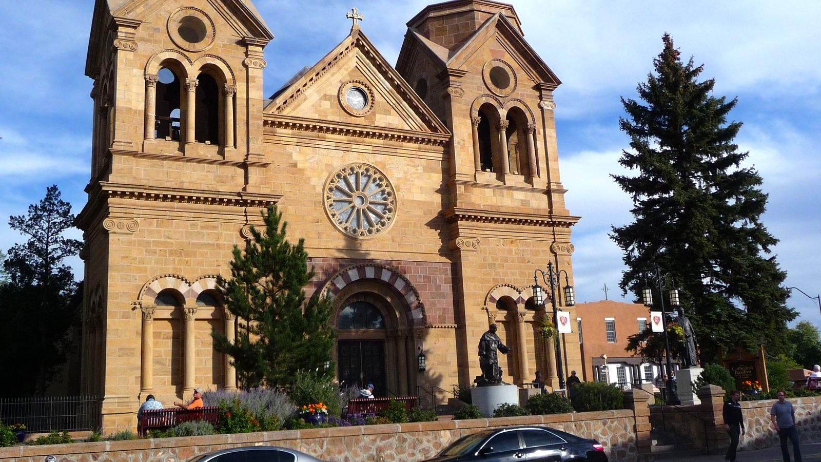 The stone twin towers and rose window of the Cathedral Basilica of Saint Francis of Assisi in Santa Fe, New Mexico, under a blue sky