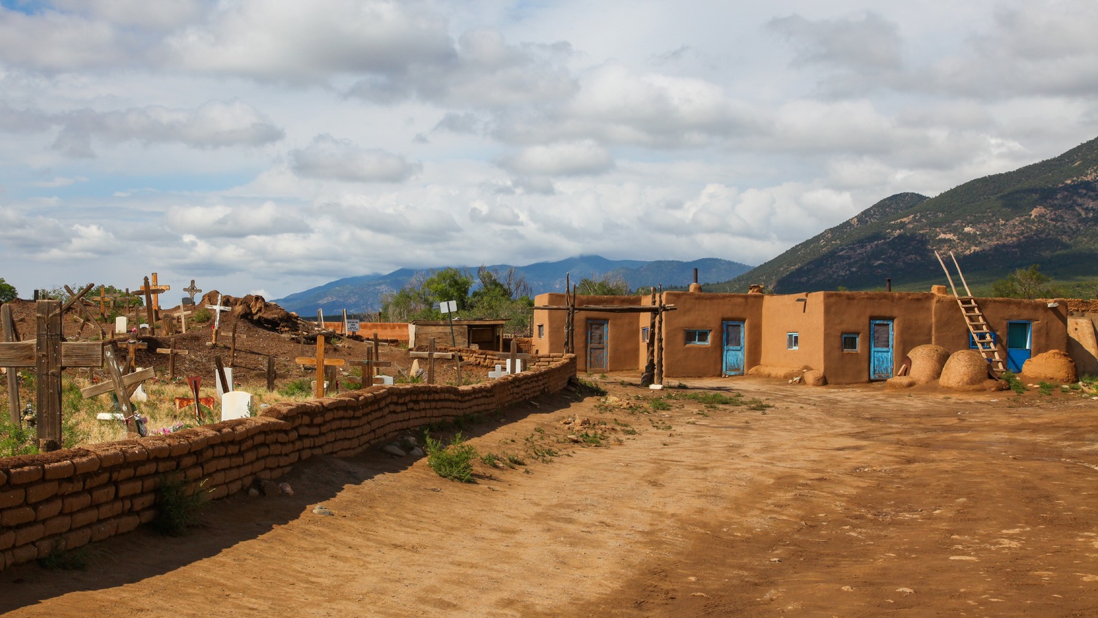 The multi storey adobe dwellings of Taos Pueblo in New Mexico with the Sangre de Cristo mountains rising behind