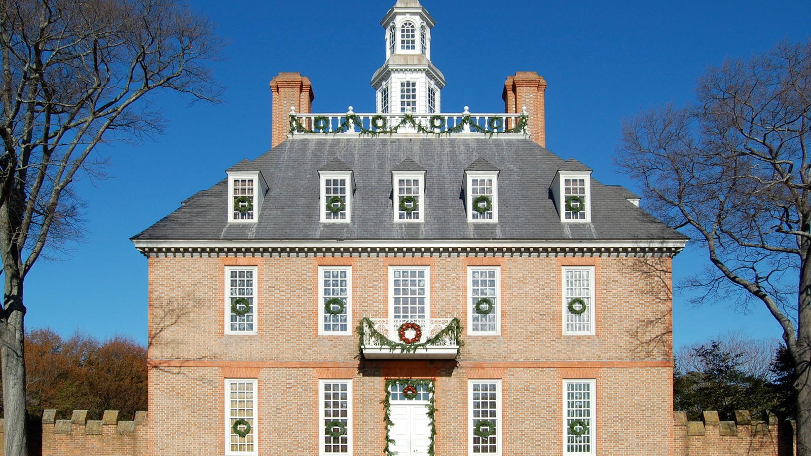 Brick facade of the Governor's Palace at Colonial Williamsburg beneath a clear blue sky