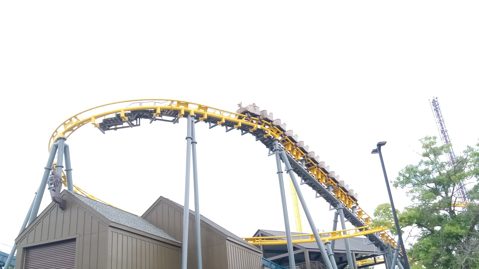 Yellow Flying Viking family coaster track curving above a building at Adventureland Iowa
