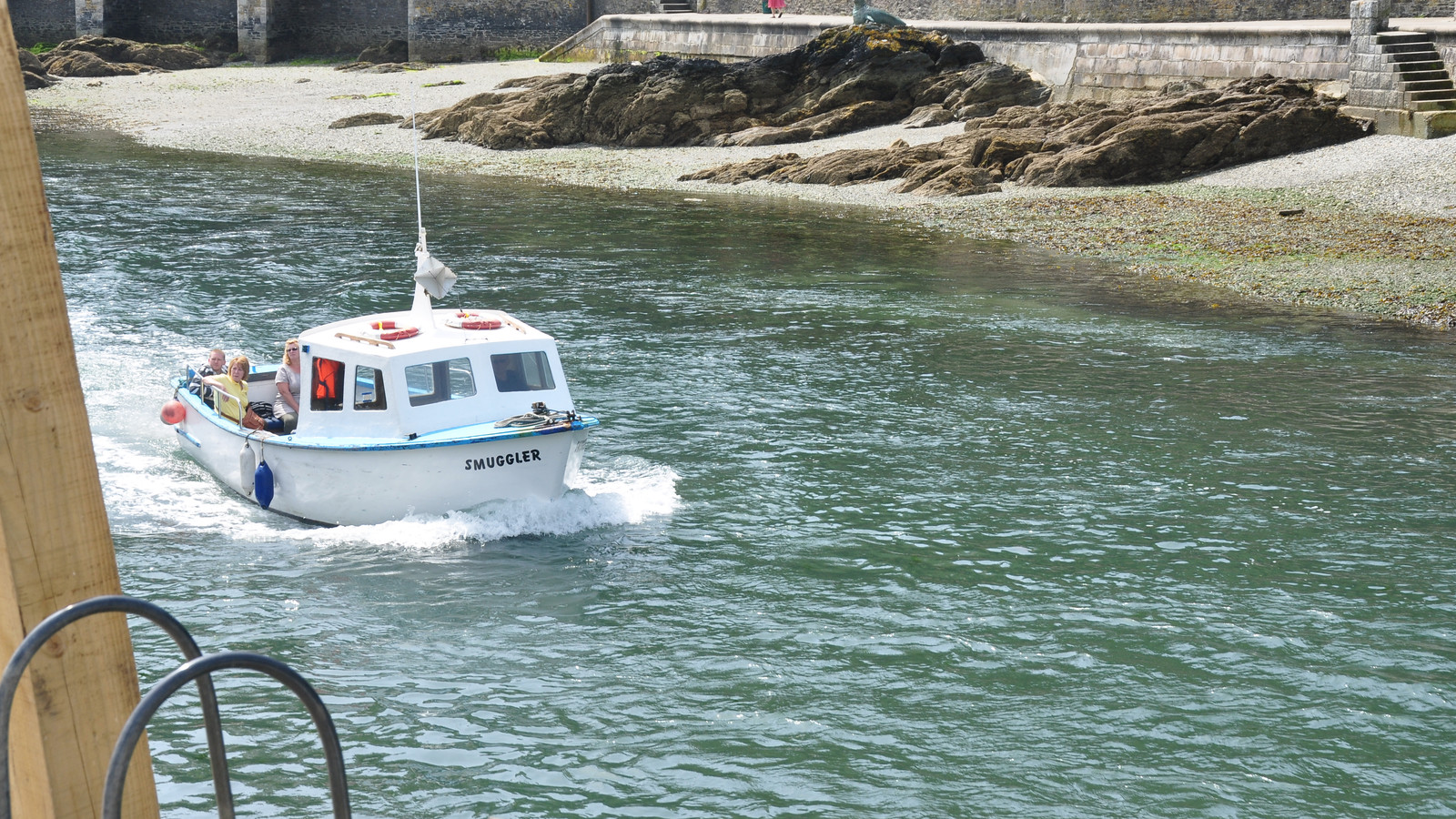 Fishing boat and waterfront buildings in Looe Harbour.
