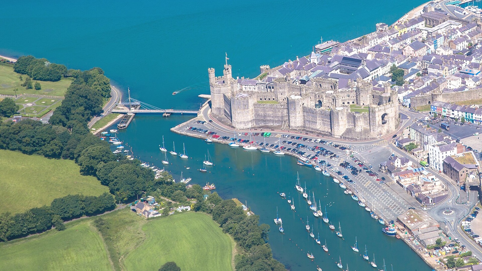 Caernarfon Castle walls and towers beside the town and water