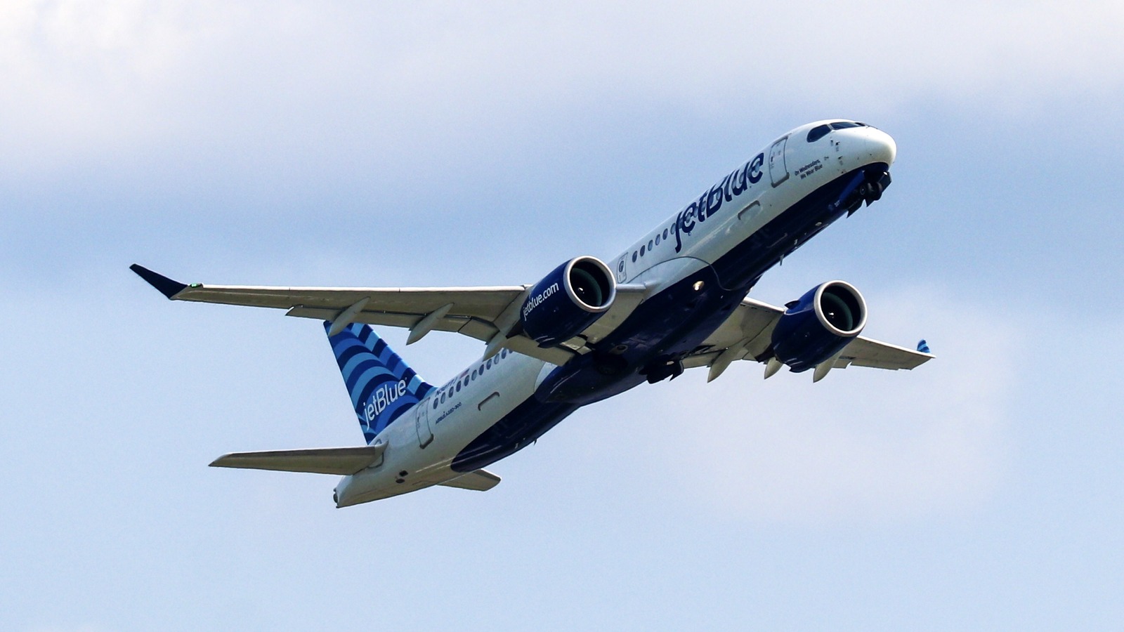 A JetBlue Airbus A220 climbing after takeoff