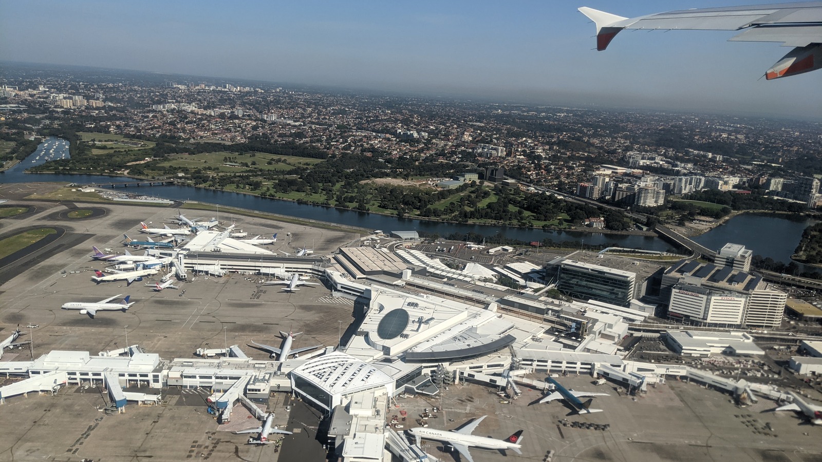 Aerial view of Sydney Airport Terminal 1 with aircraft parked at gates under clear skies
