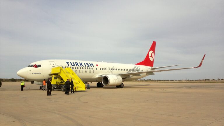A Turkish Airlines Boeing 737 parked on the apron at Misrata International Airport in Libya, with yellow airstairs at the forward door.