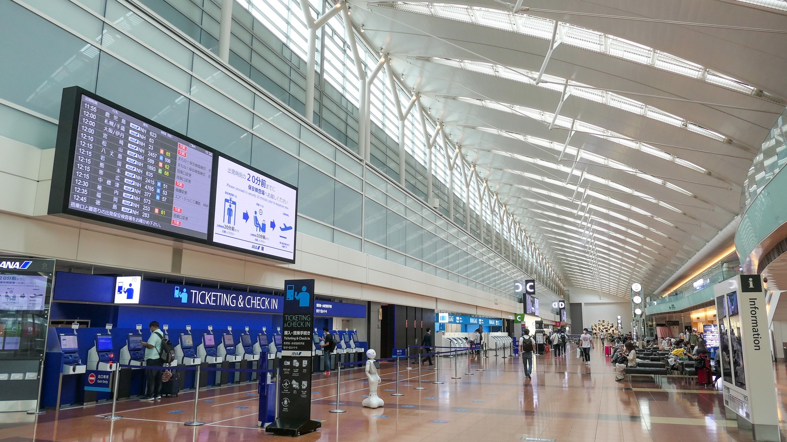 The departure lobby of Haneda Airport Terminal 2 in September 2021, with All Nippon Airways check-in kiosks under a high curved roof.
