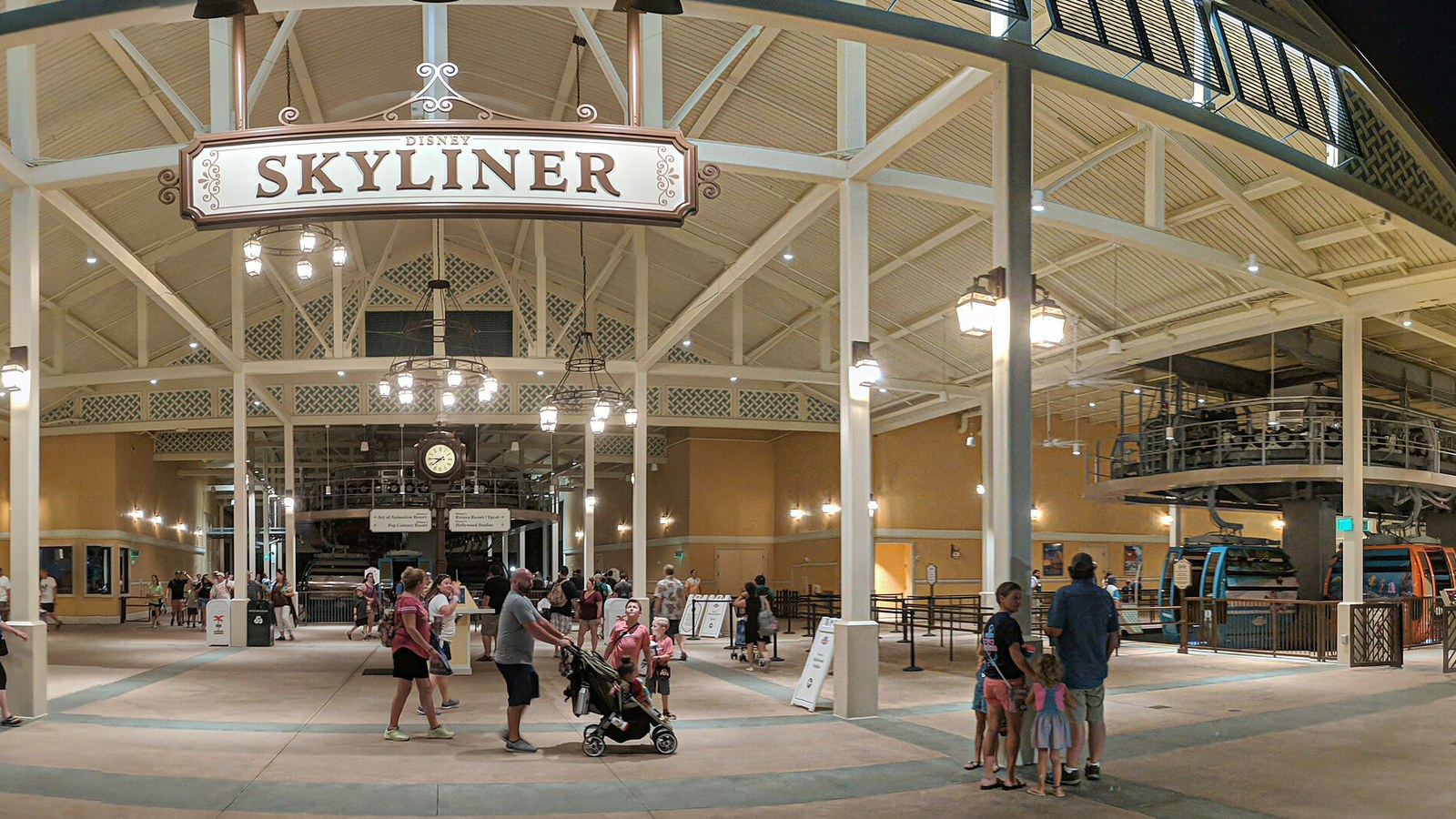 The Disney Skyliner station at Disney's Caribbean Beach Resort at night in October 2019, with gondolas at the platform and guests walking beneath the station sign
