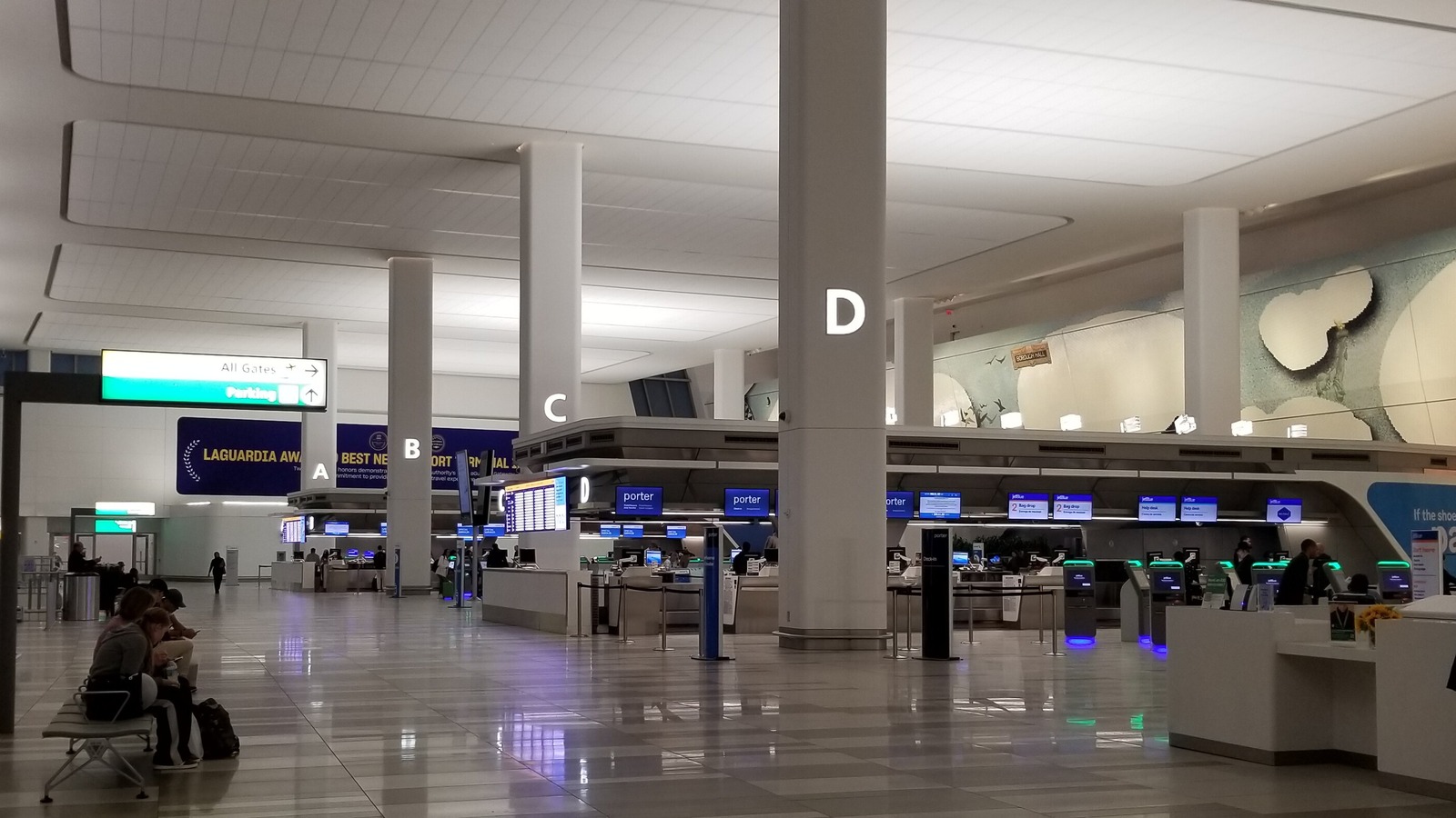 The check-in hall on Level 3 of LaGuardia Airport's Terminal B, with lettered pillars and airline counters.