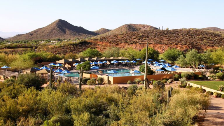 Pool deck, blue umbrellas, and desert hills at JW Marriott Tucson Starr Pass Resort in Arizona