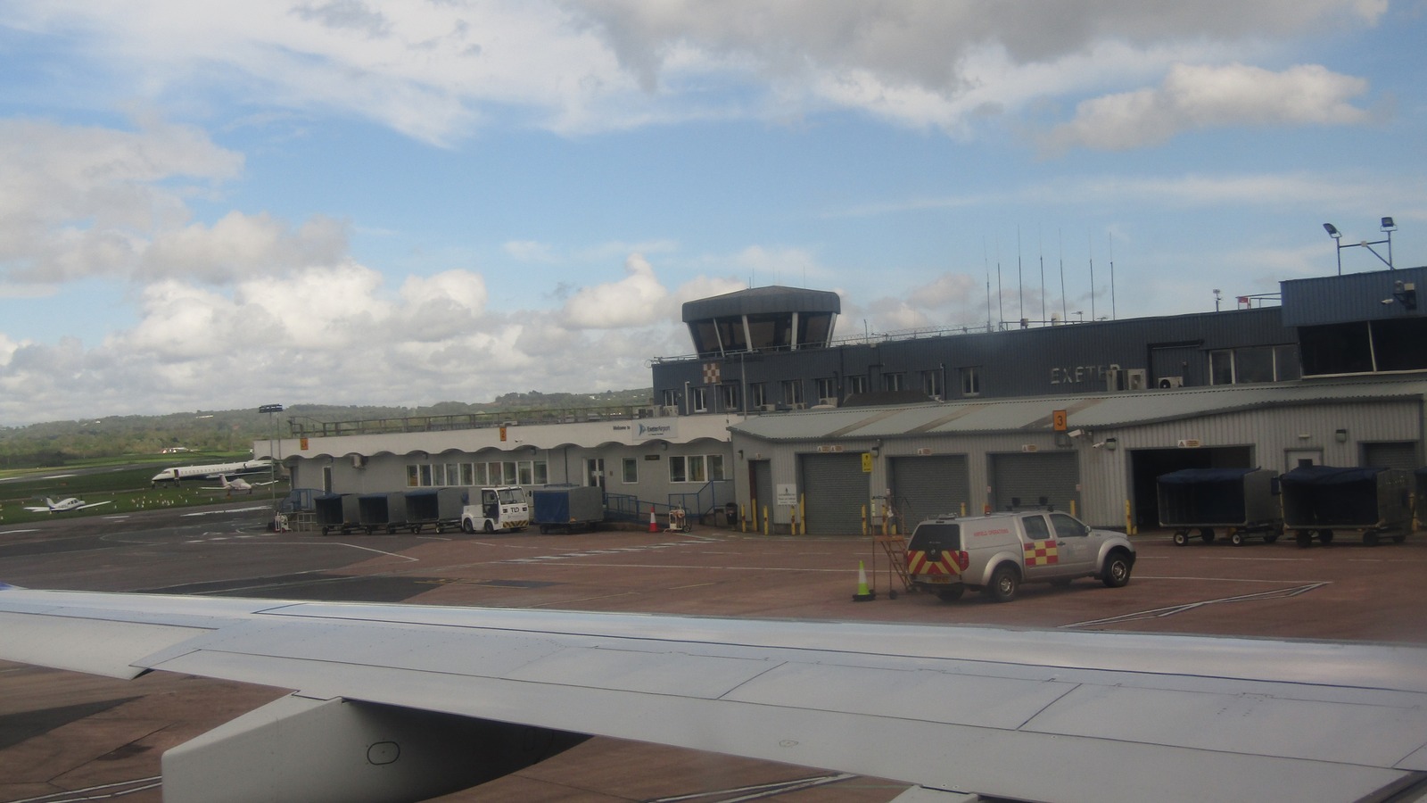 Exeter Airport terminal and control tower on the apron, with EXETER lettering on the building