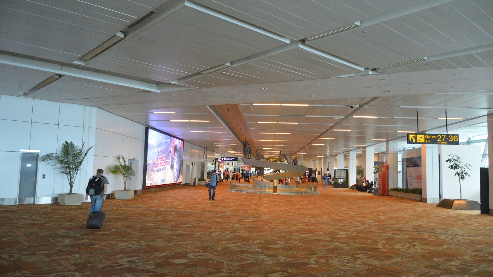 The Terminal 3 departures concourse at Indira Gandhi International Airport in New Delhi, with a sign for gates 27 to 36.