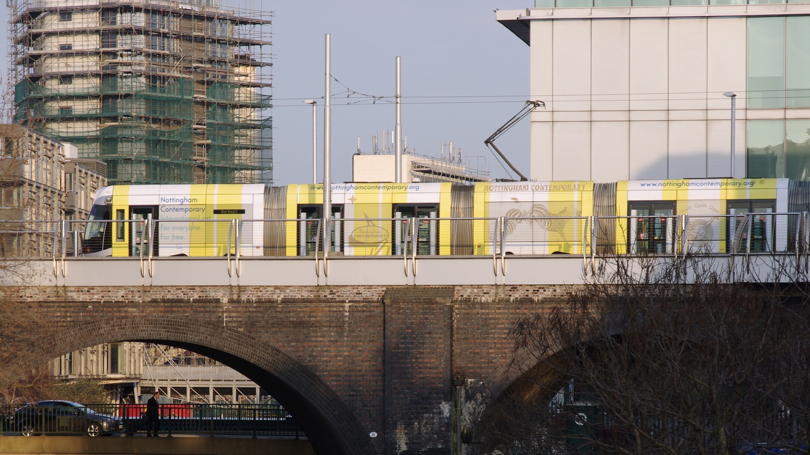 A Nottingham Express Transit tram crossing a brick canal viaduct in Nottingham