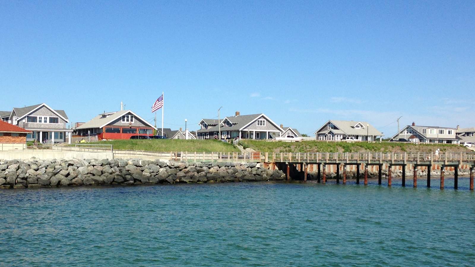 Oak Bluffs waterfront houses and pier on Martha's Vineyard seen from the water under a clear sky