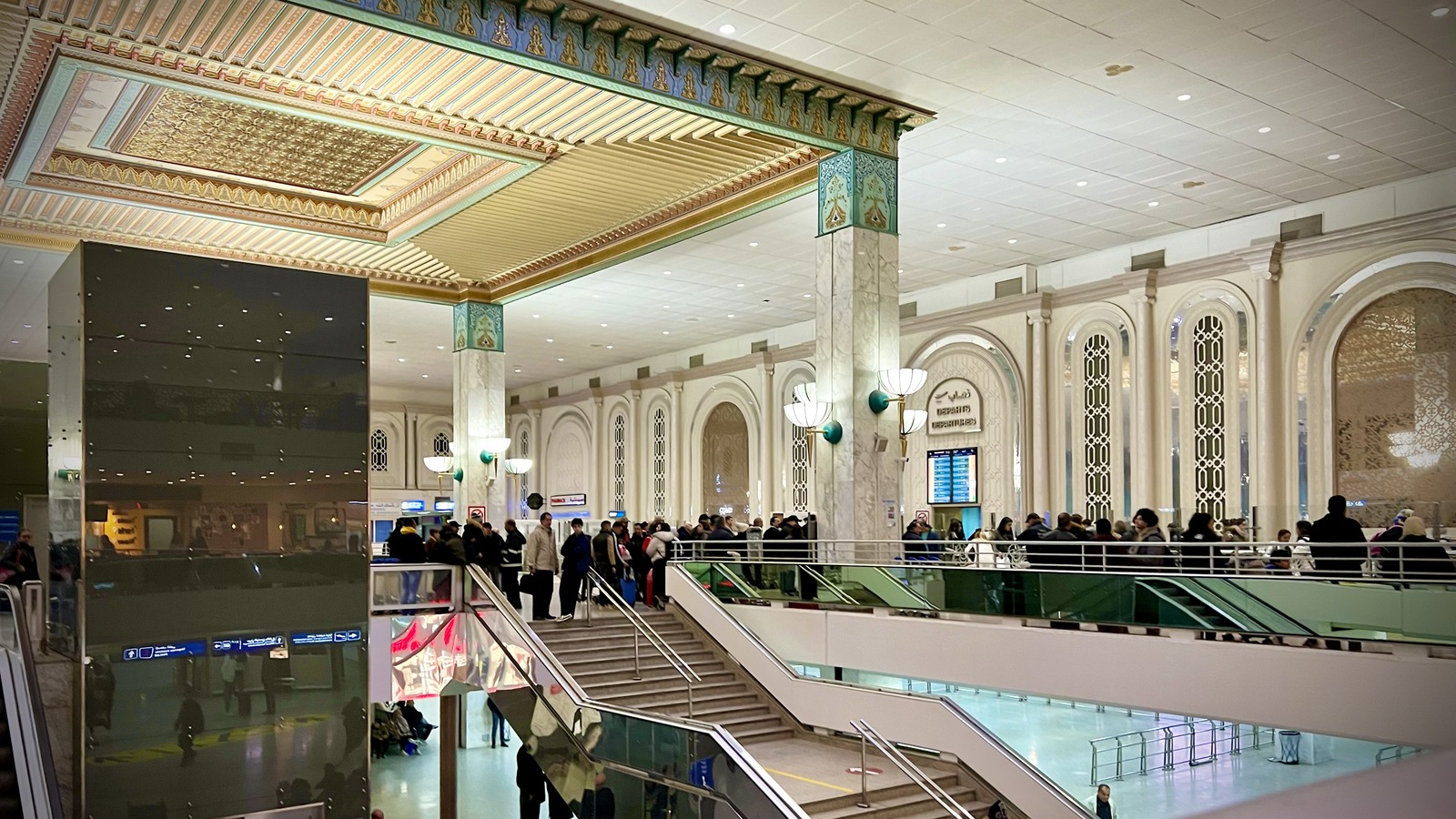 Interior of Tunis-Carthage International Airport terminal with passengers near departure boards