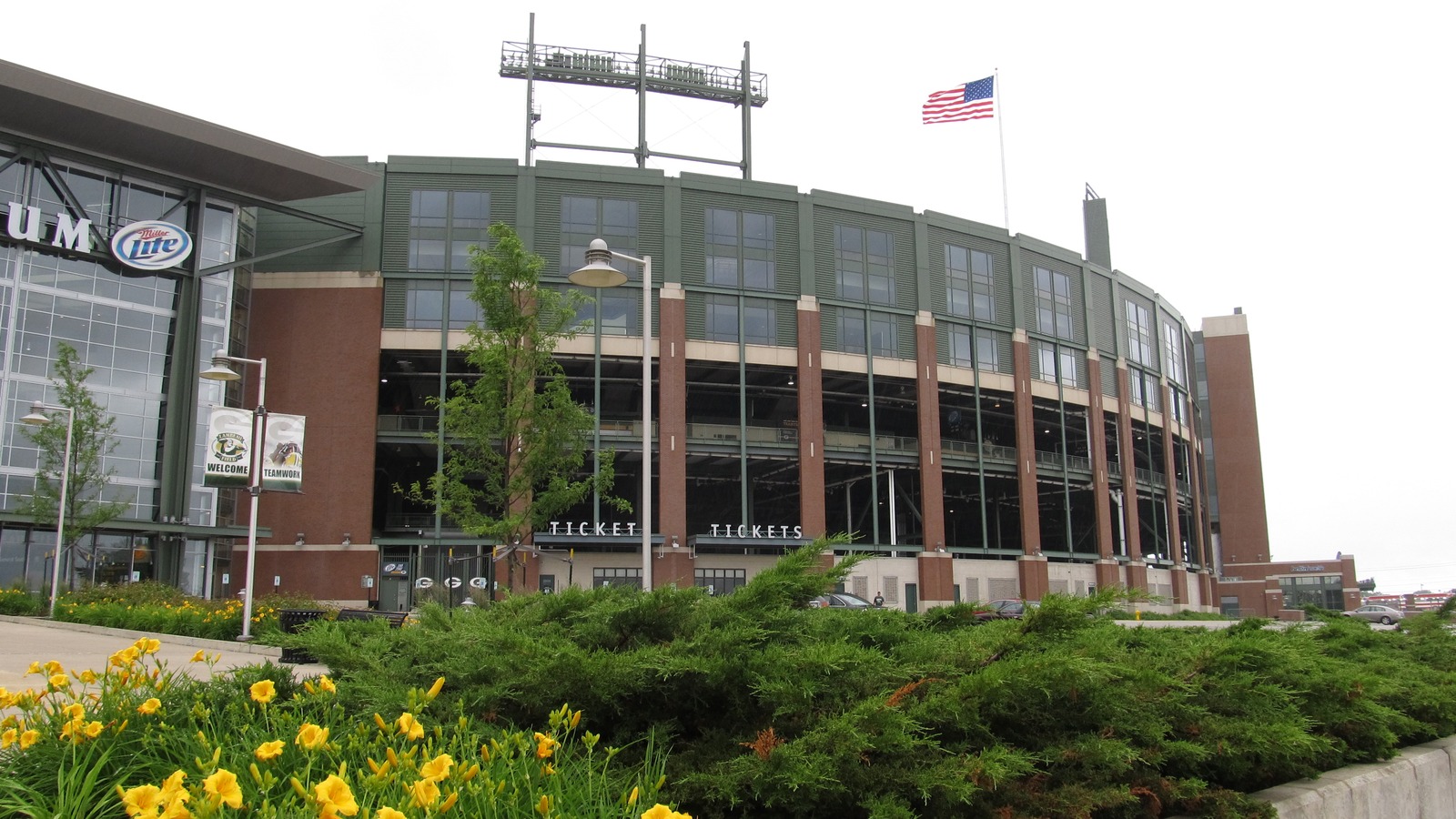 The brick and green exterior of Lambeau Field in Green Bay, with ticket windows visible along the stadium bowl.