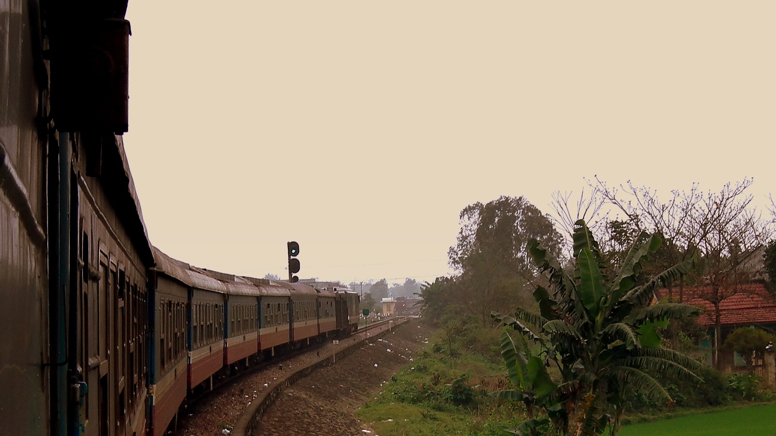 A Vietnam Railways SE8 train curves along the north-south line between Nha Trang and Da Nang in January 2012, with rice fields beside the track.