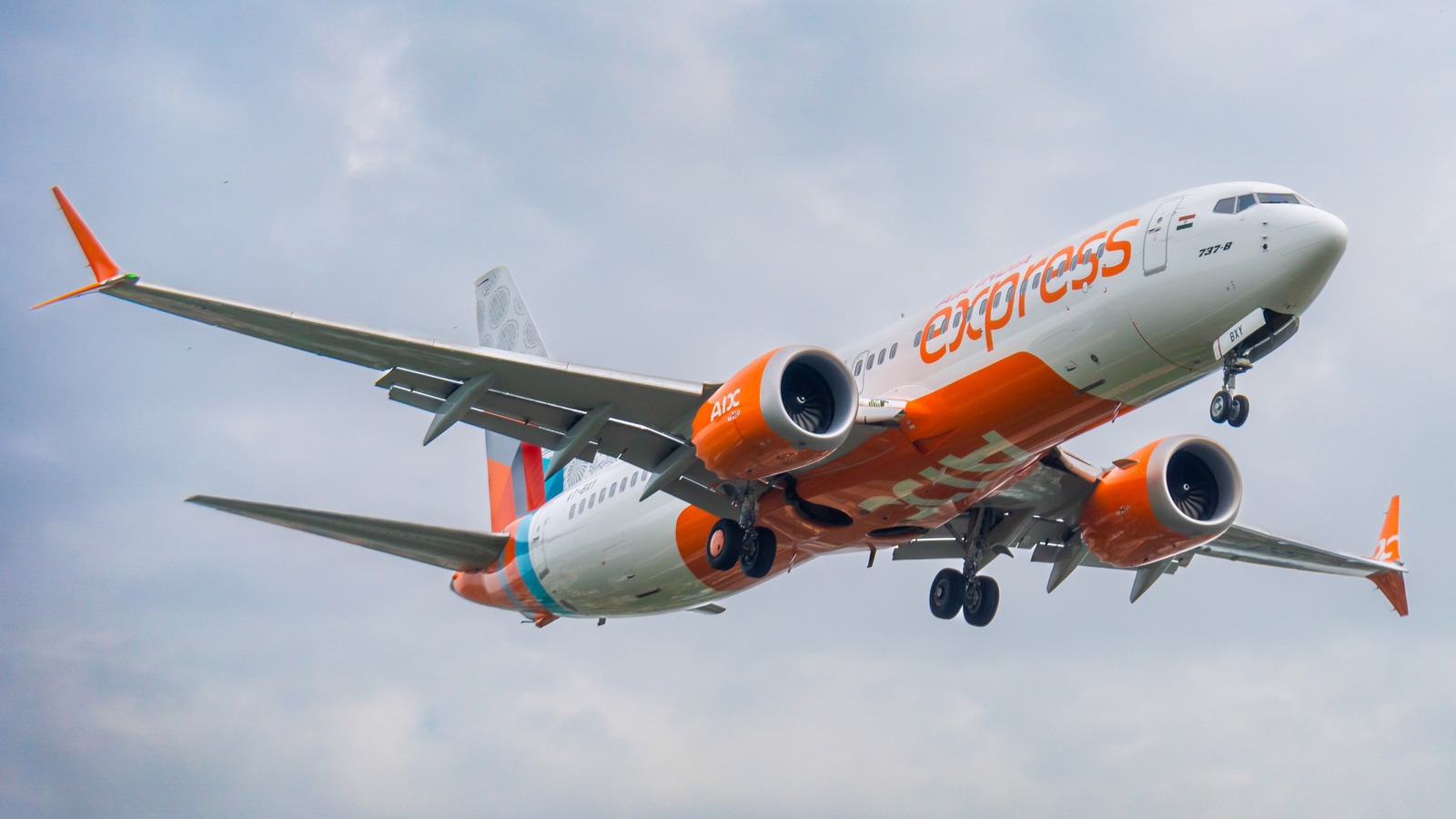 An Air India Express Boeing 737 MAX 8 in the orange and white express livery on approach with its landing gear down.