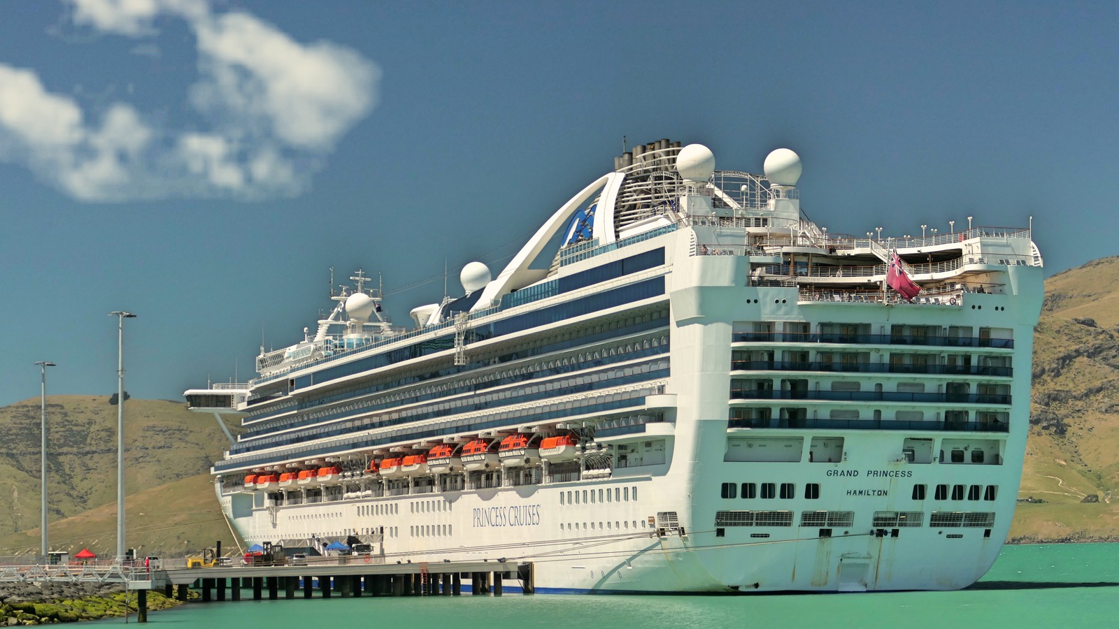 Stern view of the Grand Princess cruise ship docked at a pier under a clear sky
