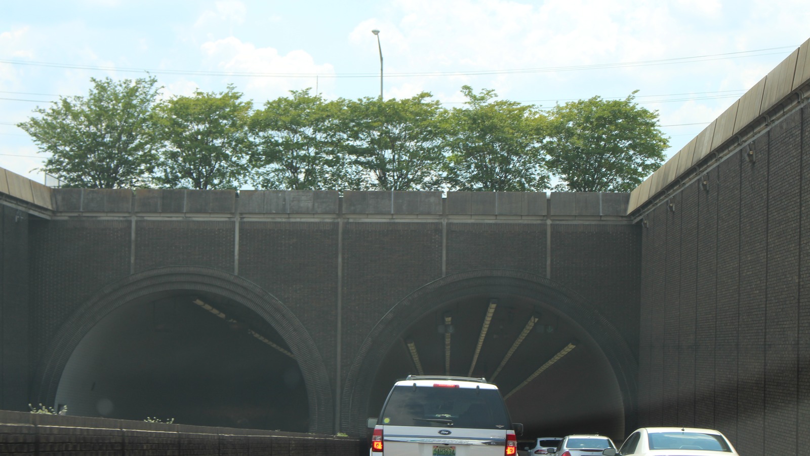 Westbound Interstate 10 traffic approaching the brick arched entrance of the George Wallace Tunnel in Mobile, Alabama
