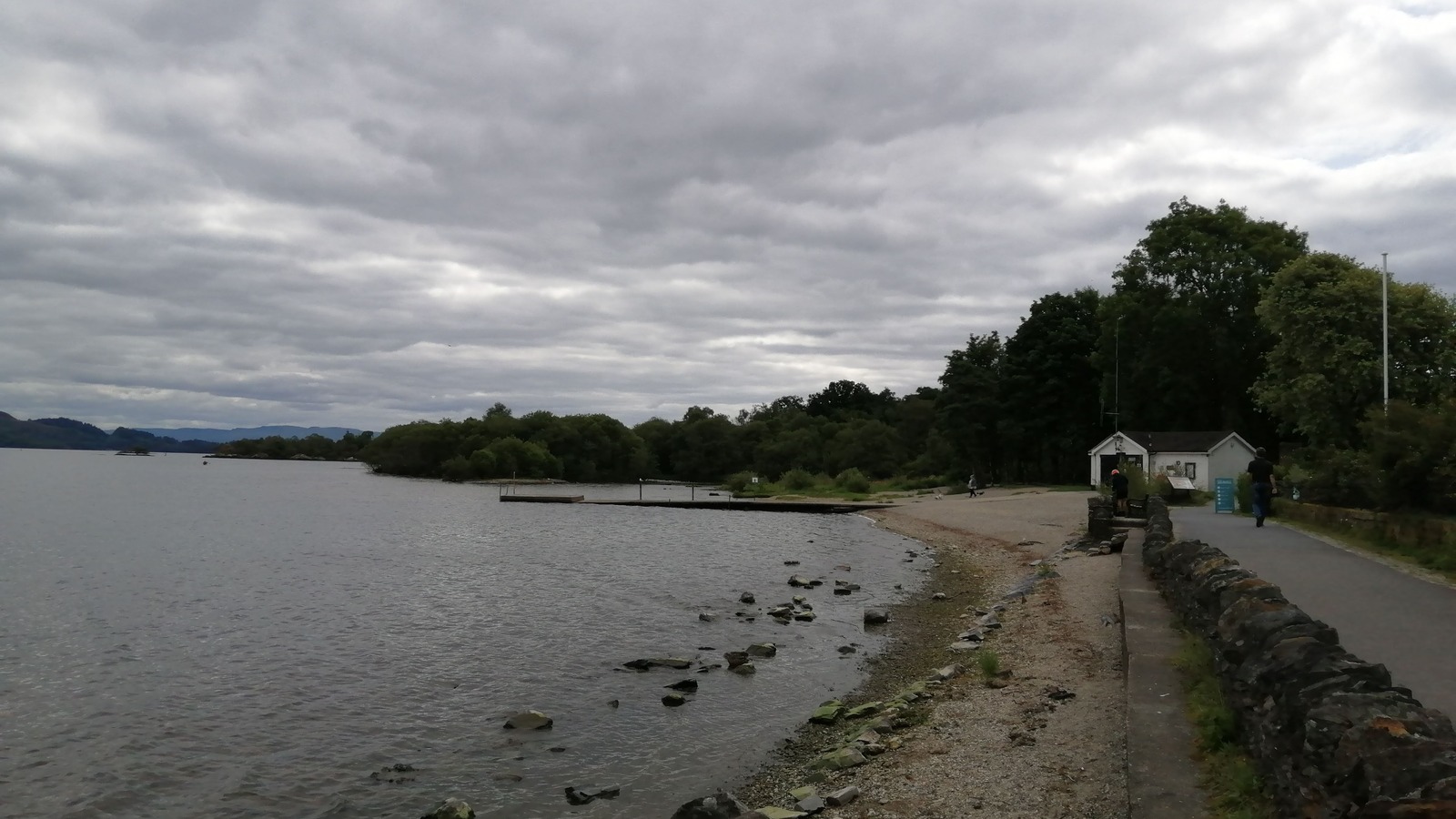 Loch Lomond shoreline path and pier at Luss under a cloudy sky
